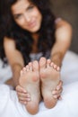 Beautiful feet, lying in the bed of a young woman Royalty Free Stock Photo