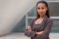 Beautiful female african american business woman CEO in a suit at the workplace, standing confidently with arms folded Royalty Free Stock Photo