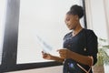 beautiful female african medical worker holding x-ray.