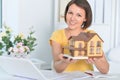 Beautiful female architect working in modern office holding house model Royalty Free Stock Photo