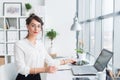 Beautiful female assistant calling using cellphone. Young office worker speaking on the mobile phone having business Royalty Free Stock Photo