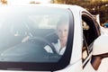 Beautiful female blonde driver behind the wheel of a white car Royalty Free Stock Photo