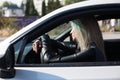 Beautiful fashionable blonde woman behind the wheel of a white car Royalty Free Stock Photo