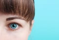 Beautiful female blue eye on a turquoise background, vision correction concept Royalty Free Stock Photo