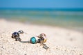 Female bracelet decoration lies on the sand on a background of blue sea and blue sky