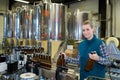 beautiful female brewery worker with bottling machinery