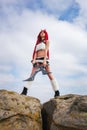 Beautiful female character with two swords on big stones Royalty Free Stock Photo