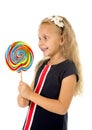 Beautiful female child with long blond hair holding huge spiral lollipop candy smiling happy Royalty Free Stock Photo