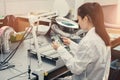 Beautiful female computer expert professional technician examining board computer in a laboratory in a factory