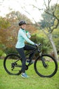 Beautiful female cyclist drinking water in forest