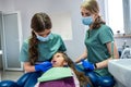 Beautiful female dentist with her assistant in medical uniform looking at children& x27;s teeth. Royalty Free Stock Photo
