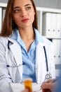 Beautiful female doctor hold in arms pad offering sign Royalty Free Stock Photo