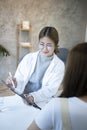 Female doctor holding digital tablet and explaining medical informations or diagnosis to her patient. Royalty Free Stock Photo