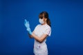 Beautiful female doctor or nurse wearing protective mask and latex or rubber gloves on grey background with copyspace Royalty Free Stock Photo