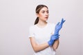 Beautiful female doctor or nurse wearing protective mask and latex or rubber gloves on grey background with copyspace. Health care Royalty Free Stock Photo