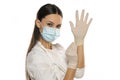 Beautiful female doctor or nurse wearing protective mask and latex or rubber gloves on white background with copyspace Royalty Free Stock Photo