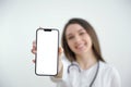 Beautiful female doctor showing a smart phone screen isolated isolated on a white background Royalty Free Stock Photo