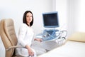 Beautiful female doctor sitting in her office near ultrasound sc Royalty Free Stock Photo