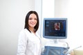 Beautiful female doctor sitting in her office near ultrasound sc Royalty Free Stock Photo