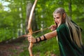 Beautiful female elf archer in the forest hunting with a bow Royalty Free Stock Photo