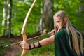 Beautiful female elf archer in the forest hunting with a bow Royalty Free Stock Photo