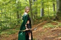 Beautiful female elf archer in the forest hunting with a bow Royalty Free Stock Photo