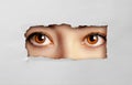 Beautiful female eyes looking through a hole cardboard Royalty Free Stock Photo