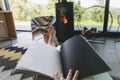 Beautiful female feet and book on background of warm fireplace and big window in modern cozy chalet Royalty Free Stock Photo