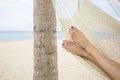 Beautiful female feet in a hammock on the beach