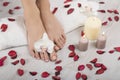 Beautiful female feet and hands with french manicure on white towel. Spa, foot care