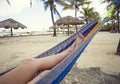 Beautiful female feet and legs relaxing in a hammock on the beach