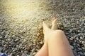 Beautiful female feet on pebbles on the beach on a Sunny summer day Royalty Free Stock Photo