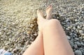Beautiful female feet on pebbles on the beach on a Sunny summer day Royalty Free Stock Photo
