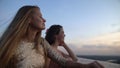 Beautiful female friends enjoying view from terrace watching sunset, tranquility