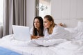 Two concentrated women in bed with laptop Royalty Free Stock Photo