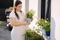 Beautiful female gardening outdoor. Happy woman hold metal bucket with daffodils. Flowerbed on balcony