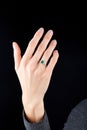 Beautiful female hand with gold ring with diamonds and emerald on black background