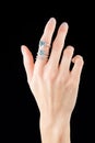 Beautiful female hand with gold ring with diamonds and emerald on black background