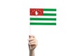 Beautiful female hand holding Abkhazia flag, isolated on white background