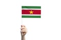 Beautiful female hand holding Suriname flag, isolated on white background