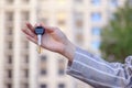beautiful female hand holds the keys to the house, apartment, on the background of city. Royalty Free Stock Photo