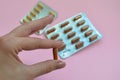 A beautiful female hand holds a medical pharmaceutical pill capsule from coronavirus Covid-19 for the treatment of diseases Royalty Free Stock Photo