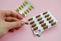 A beautiful female hand holds a medical pharmaceutical pill capsule from coronavirus Covid-19 for the treatment of diseases Royalty Free Stock Photo