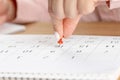 Beautiful female Hand with manicure pushes a red pin on a calendar 16 day Royalty Free Stock Photo