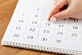 Beautiful female Hand with manicure pushes a red pin on a calendar 16 day Royalty Free Stock Photo