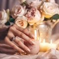 Beautiful female hand with nail polish manicure and wedding ring, rose flowers bouquet on background. Romantic dinner close-up Royalty Free Stock Photo