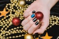 Beautiful female hand with black and blue nail design. Christmas manicure. Royalty Free Stock Photo