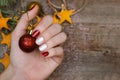 Beautiful female hand with red and white nail design. Christmas manicure. Royalty Free Stock Photo