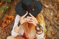 Beautiful female hands with boho chic dreamcatcher bracelets and black leather hat Royalty Free Stock Photo