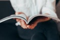 Beautiful female hands hold an open book or magazine in the room Royalty Free Stock Photo